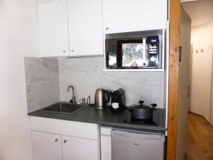 a kitchen with a sink and a microwave at Résidence Combettes - Studio pour 4 Personnes 071 in Les Contamines-Montjoie