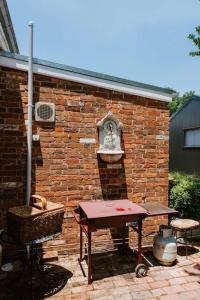 una pared de ladrillo con una mesa de picnic y una parrilla en Cawarra on the Park - Historic Mudgee Grandeur en Mudgee