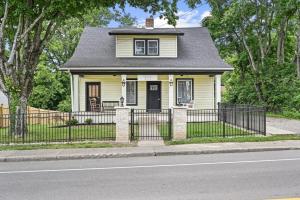 ein gelbes Haus mit einem schwarzen Zaun auf einer Straße in der Unterkunft Bungalow on Main - Near Ark in Williamstown