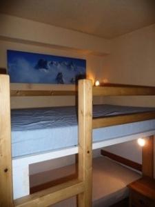 two bunk beds in a room with a painting on the wall at Résidence Neige Et Glace - Studio pour 4 Personnes 901 in Val-d'Isère