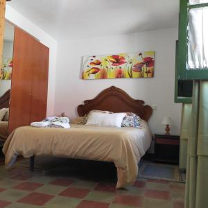 Alborada Dos في Alcalá del Río: غرفة نوم مع سرير مع اللوح الأمامي الخشبي
