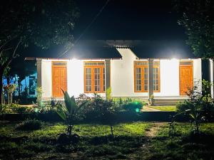 a white house with orange doors at night at Sunrise oasis retreat in Habarana