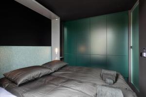 1 dormitorio con 1 cama grande y paredes verdes en Unique Modern Cabin with Views 