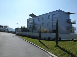 un grand bâtiment blanc sur le côté d'une route dans l'établissement Résidence Villa Neree - 3 Pièces pour 5 Personnes 404, à Aix-les-Bains