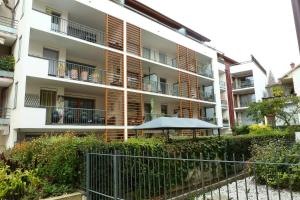 um edifício de apartamentos com um guarda-chuva em frente em Residence L'albizia - 2 Pièces pour 4 Personnes 594 em Aix-les-Bains
