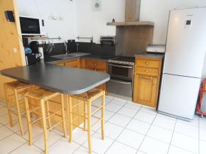 uma cozinha com um frigorífico e uma mesa com bancos em Residence L'albizia - 2 Pièces pour 4 Personnes 594 em Aix-les-Bains