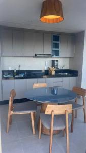 a kitchen with a blue table and two chairs at Apartamento em Ondina com acesso à praia (Beach Class Salvador) in Salvador