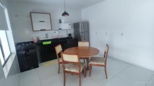 a kitchen with a table and chairs and a refrigerator at Casa mobiliada de 2 suítes na R São Lázaro 2367 - 2370 - Jardim Gonzaga in Juazeiro do Norte