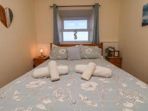 a bedroom with a bed with two pillows and a window at Kerensa ha-Kres in Sennen