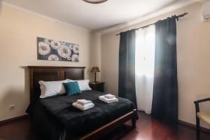 a bedroom with a bed with two towels on it at Peaceful Retreat in Mosteiros
