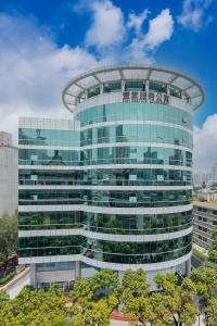 un grand bâtiment en verre avec un dôme dans l'établissement CM Serviced Apartment Shenzhen Dongmen, à Shenzhen