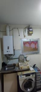 een keuken met een wastafel en een wasmachine bij شقة مفروشة بمدينة الشروق in Madīnat ash Shurūq