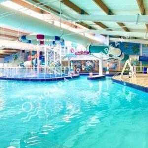 a large swimming pool with a water slide at Aloha - Cosy 2 Bed Close to Venue at Seal Bay, Selsey in Chichester