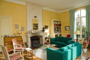 een woonkamer met een blauwe bank en een open haard bij Home Sweet Home - Celle Saint Cloud Versailles in La Celle-Saint-Cloud