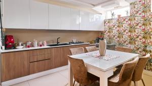 cocina con mesa blanca y sillas en VILLA NADIA, en Boscoreale