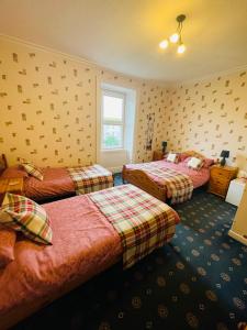ein Hotelzimmer mit 3 Betten und einem Fenster in der Unterkunft The Limes Guest House in Montrose