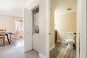 a bathroom with a toilet and a dining room at Gondola Heights by Outpost Whistler in Whistler