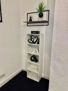 une étagère avec des chaussures et une plante sur un mur dans l'établissement Sea forth Cosy Crib 7 - NightsOffer, à Leeds