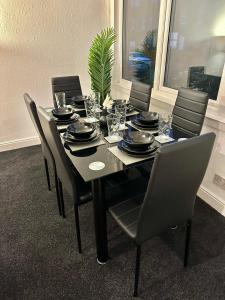 une table à manger avec des chaises, des assiettes et une plante dans l'établissement Sea forth Cosy Crib 7 - NightsOffer, à Leeds
