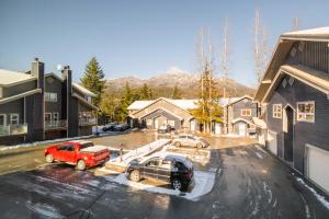 two trucks parked in a parking lot in front of houses at Gondola Heights by Outpost Whistler in Whistler
