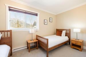 sypialnia z 2 łóżkami i oknem w obiekcie Gondola Heights by Outpost Whistler w mieście Whistler