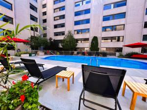 - une terrasse avec des chaises et une piscine dans un bâtiment dans l'établissement Hotel Universel Montréal, à Montréal