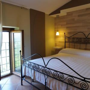 um quarto com uma cama e uma grande janela em Al Piccolo Borgo Locanda Con Alloggio em Castelnuovo Parano