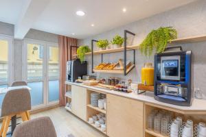 a kitchen with a counter with a tv and food at Urban Hotel & Spa Aix-les-Bains - BW Signature Collection in Aix-les-Bains