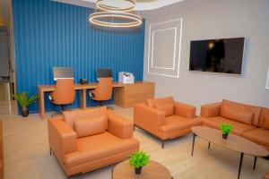 a waiting room with orange furniture and a flat screen tv at Best Western Premier DJ Hotel in Djibouti