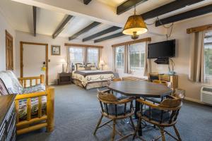 uma sala de estar com uma mesa e uma cama em Apache Motel em Moab