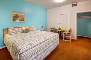 1 dormitorio con 1 cama grande y 1 mesa en Apache Motel en Moab