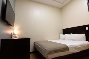 una camera da letto con un letto e una TV a schermo piatto di Hotel Dunas Near Consulate a Ciudad Juárez