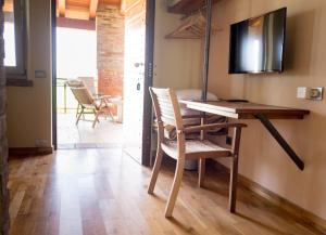 a room with a desk and a television on a wall at Parma Country Room in Montechiarugolo