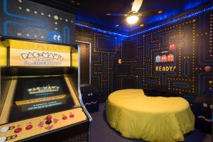a room with a video game machine in it at 10 Acre Lakefront Game House - Sleep Upto 45 in Clermont