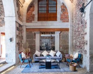 une terrasse avec un canapé, des chaises et une cheminée dans l'établissement Casa de la Luz Hotel Boutique, à Mexico