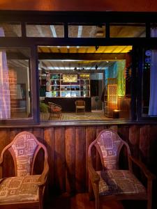 two chairs in front of a bar with a mirror at Pousada Holística Alto do Sol in Nova Friburgo