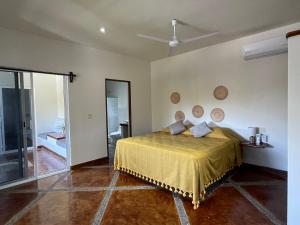 sypialnia z łóżkiem i wentylatorem sufitowym w obiekcie Casa de las Aves w mieście Puerto Escondido