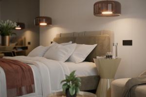 una camera da letto con letto, lenzuola e cuscini bianchi di Hayat Sky Hotel a Rust