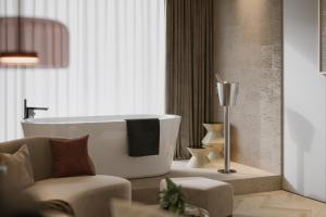 uma casa de banho com uma banheira, uma cadeira e um sofá em Hayat Sky Hotel em Rust