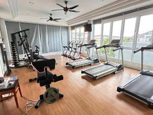 a gym with a bunch of treadmills and exercise bikes at ประกายทอง พูลวิลล่า 