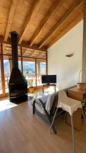 a living room with a fireplace and a chair at Allotjaments rurals Can Punti in Vallfogona de Ripolles