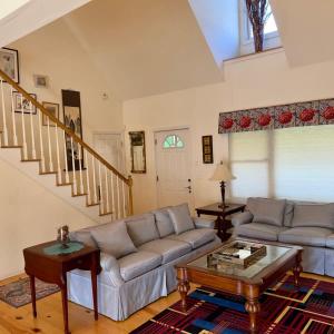 a living room with a couch and a table at Modern Lakehouse Retreat by CozySuites in Copake