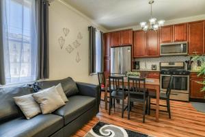 a living room with a couch and a kitchen with a table at Modern 3BR2BA Apartment Minutes to NYC in Jersey City