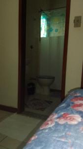a bedroom with a bathroom with a toilet and a window at Hospedaria Meu Lar in Rio das Ostras