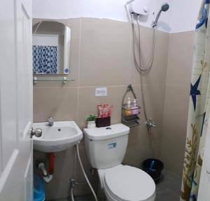 a bathroom with a toilet and a sink and a shower at Mango Transient House in Angeles