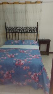 a bedroom with a bed with a blue comforter at Hospedaria Meu Lar in Rio das Ostras