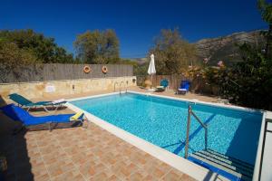 basen z 2 leżakami obok niego w obiekcie Avvisania Villa w mieście Agia Efimia
