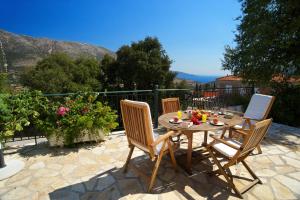 a wooden table and chairs on a patio at Avvisania Villa in Ayia Evfimia