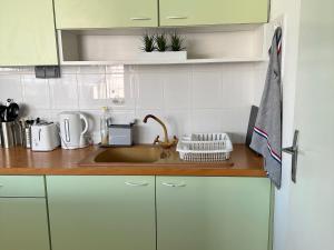 uma cozinha com armários brancos e um lavatório em Bungalow Marie em Saint-François