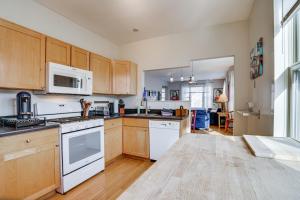 a kitchen with white appliances and wooden cabinets at Pet-Friendly Saint Paul Vacation Rental with Deck! in West Saint Paul +18 photos